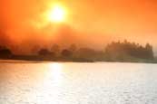 The sun setting through the mist above Balthayock Loch, near Perth, Perthshire, Scotland